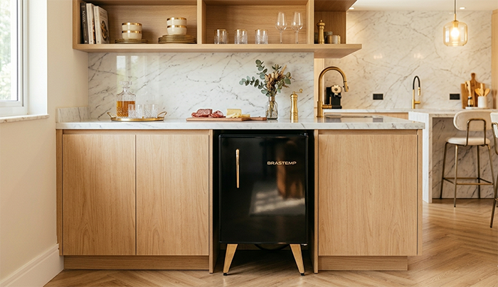 Frigobar Brastemp preto retrô moderno em cozinha gourmet sofisticada, acabamento premium brilhante, detalhes dourados, iluminação aconchegante, bancada de mármore preto, estilo luxuoso, fotografia realista ultra detalhada, alta resolução, ambiente elegante contemporâneo.